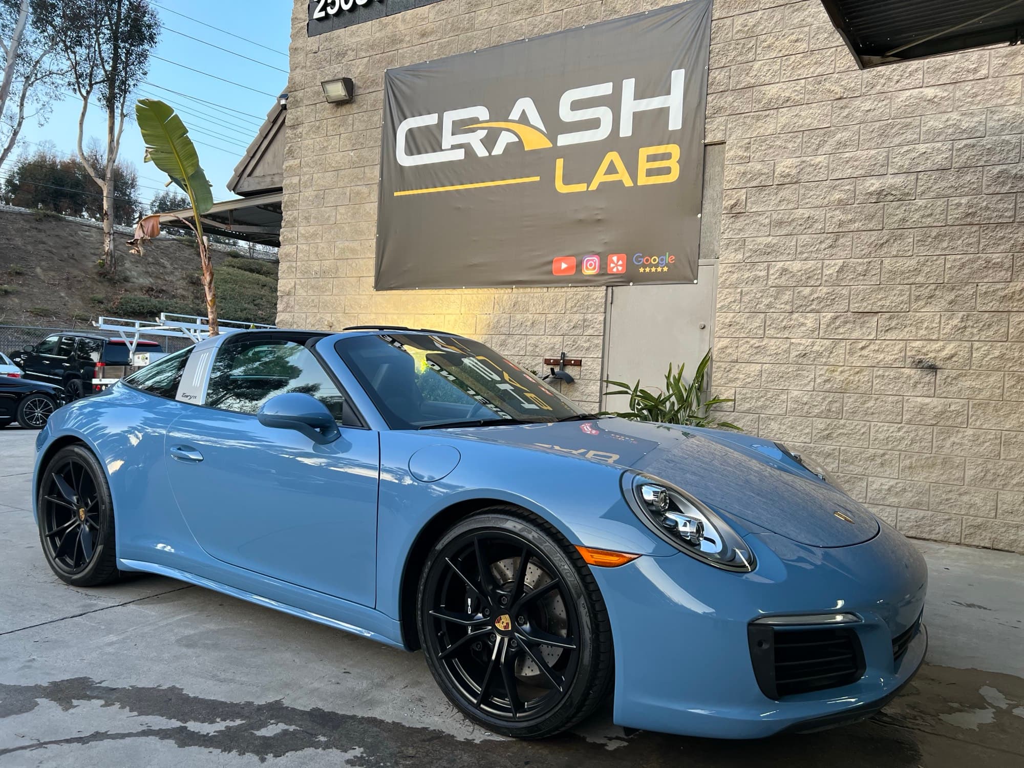Light blue Porsche 911 finished and parked in the Crash Lab lot in Lake Forest